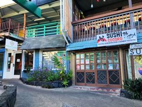 Kailua Kona apartment for rent - a building with a sushi shop and a restaurant on the street