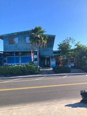 Kailua Kona apartment for rent - a blue building with a palm tree in front of it