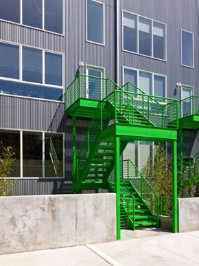 Washington apartment for rent - A green staircase with a glass balustrade is in front of a grey building.