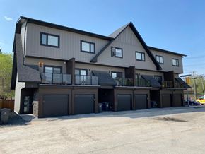 Winnipeg apartment for rent - A large two-story house with a garage on the ground floor.