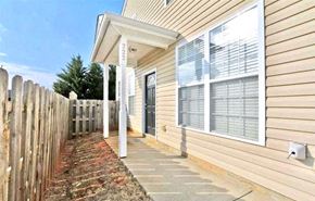 Greer house for rent - A house with a wooden fence and a brick pathway leading to the front door.