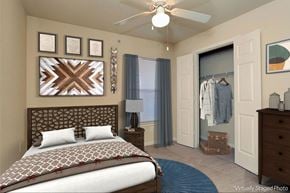 Buda townhouse for rent - a bedroom with a bed and a closet and a ceiling fan
