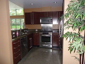 San Diego house for rent - a kitchen with stainless steel appliances and dark wood cabinets