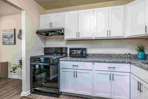 Towson apartment for rent - A kitchen with white cabinets and a black stove top oven.