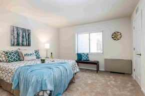 Towson apartment for rent - A bedroom with a bed, bench, and a painting on the wall.