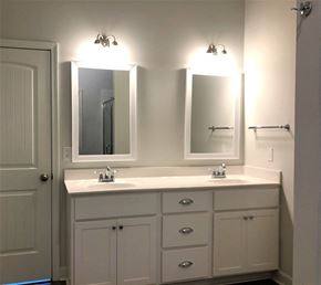 Aiken house for rent - A white bathroom vanity with two sinks and two mirrors.