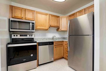 Timonium apartment for rent - A kitchen with a stainless steel refrigerator, microwave, oven, and dishwasher.