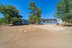Anza house for rent - the front of a house with a gravel driveway and trees