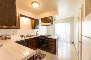 Lakewood apartment for rent - a kitchen with black appliances and wooden cabinets