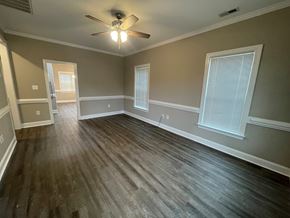 Wilson apartment for rent - A room with a ceiling fan and wooden flooring.