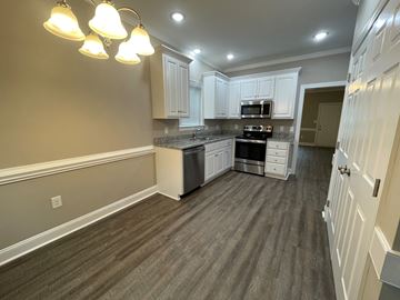 Wilson apartment for rent - A kitchen with white cabinets and a grey floor.