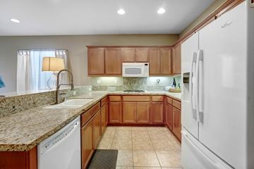 Indio house for rent - A kitchen with brown cabinets and a white refrigerator.