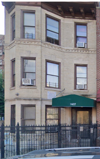 Bronx apartment for rent - a tall brick building with a green awning and windows