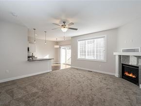 West Des Moines apartment for rent - A living room with a fireplace and a ceiling fan.