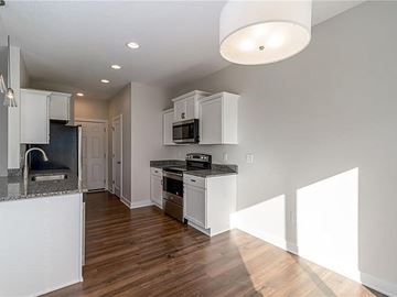 West Des Moines apartment for rent - A kitchen with white cabinets and a black countertop.