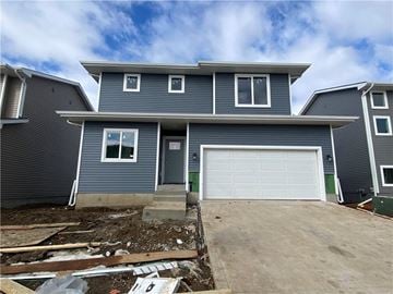 Urbandale apartment for rent - a blue house being remodeled with a driveway and a garage door
