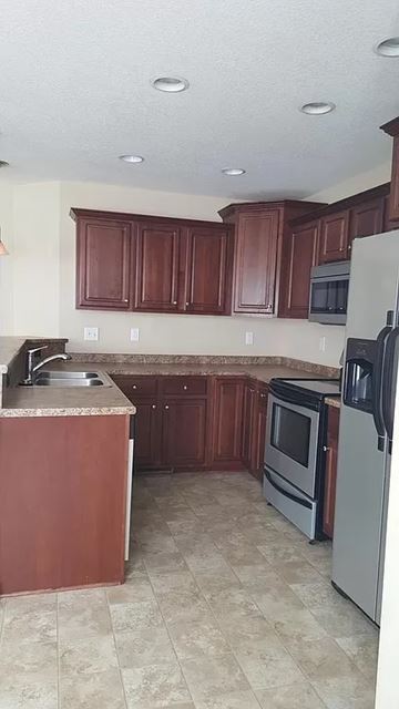 Waukee apartment for rent - A kitchen with brown cabinets and a tiled floor.