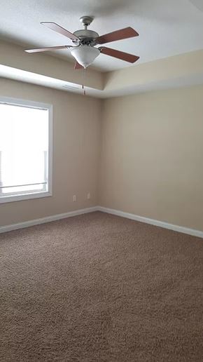 Waukee apartment for rent - A room with a ceiling fan and carpeted floor.