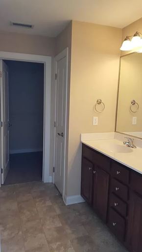 Waukee apartment for rent - A bathroom with a sink, mirror, and cabinets.