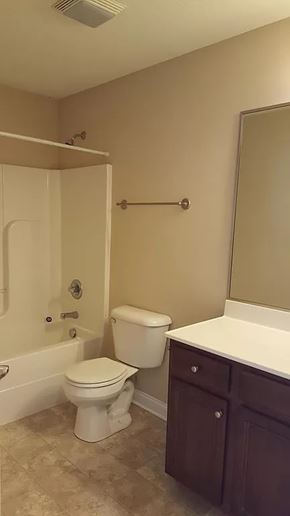 Waukee apartment for rent - A white toilet sits in a bathroom next to a white sink.
