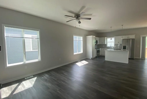 Urbandale apartment for rent - A spacious room with wooden floors and a ceiling fan.