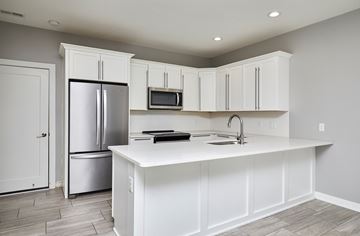 Waukee apartment for rent - A kitchen with white cabinets and a white island.