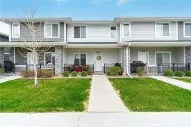 Waukee apartment for rent - A row of houses with a white fence in front.