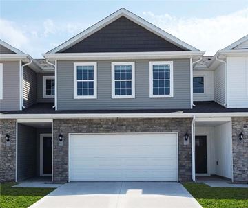 Waukee apartment for rent - A modern house with a grey and white exterior and a large garage door.
