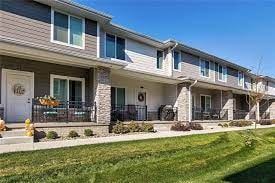 Waukee apartment for rent - A row of houses with front yards and driveways.