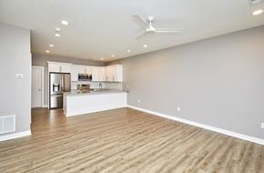 Waukee apartment for rent - A spacious room with wooden flooring and a ceiling fan.