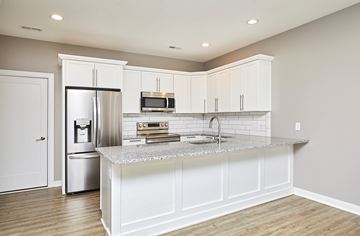 Waukee apartment for rent - A kitchen with white cabinets and a granite countertop.
