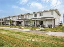 Waukee apartment for rent - A row of houses with a grassy area in front.