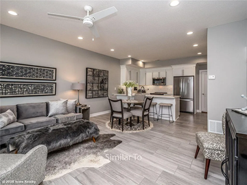 Waukee apartment for rent - A modern living room with a grey couch and a dining table set up.