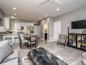 Waukee apartment for rent - A dog is lying on a rug in a well-lit room with a kitchen area and a dining table.