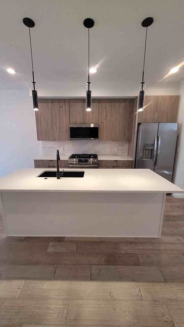 Denver apartment for rent - A modern kitchen with a white countertop and a black stove.