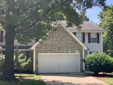 Lenexa apartment for rent - a stone house with a white garage door