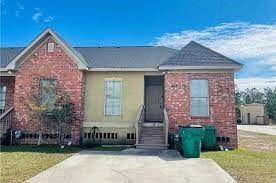 Slidell apartment for rent - the front of a brick house with two trash cans in front