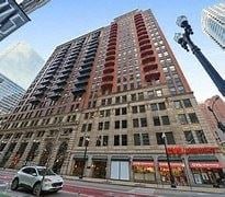 Chicago apartment for rent - A tall building with a red brick facade stands next to a shorter building with a beige facade.