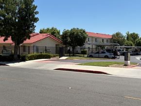 Perris apartment for rent - A street view of a residential area with houses and a parked car.
