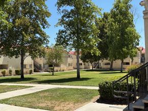 Perris apartment for rent - A grassy area with trees and a building in the background.