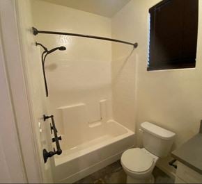 Tulare house for rent - a white bathroom with a toilet and a tub