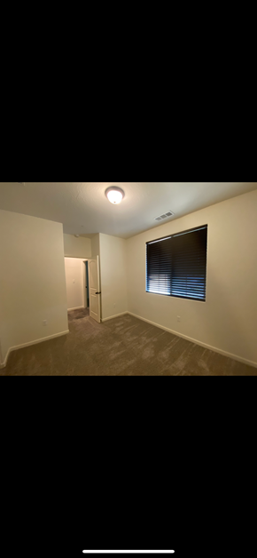 Tulare house for rent - an empty living room with a window and a ceiling light