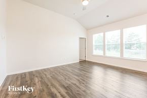 Greenville house for rent - A spacious room with wooden flooring and a ceiling fan.