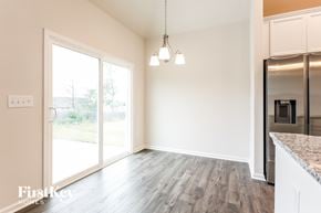 Greenville house for rent - A kitchen area with a refrigerator, cabinets, and a countertop.