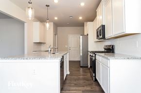 Greenville house for rent - a kitchen with white cabinets and a white counter top