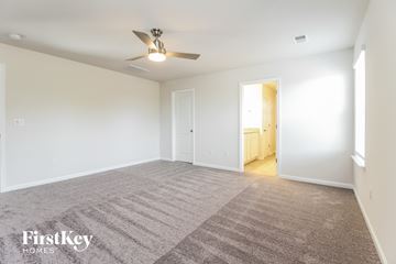 Greenville house for rent - a spacious living room with carpet and a ceiling fan