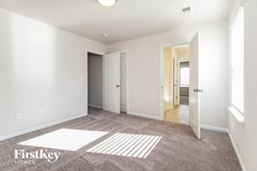 Greenville house for rent - a master bedroom with carpeted flooring and white walls