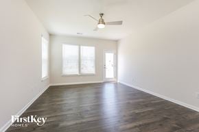 Simpsonville house for rent - A spacious room with wooden floors and a ceiling fan.