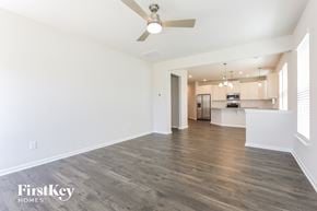 Simpsonville house for rent - A spacious room with a ceiling fan and wooden flooring.