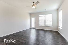 Simpsonville house for rent - A spacious room with a ceiling fan and wooden flooring.
